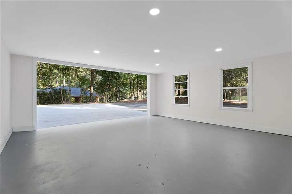 Spacious room featuring a concrete floor, recessed lighting, and multiple windows
