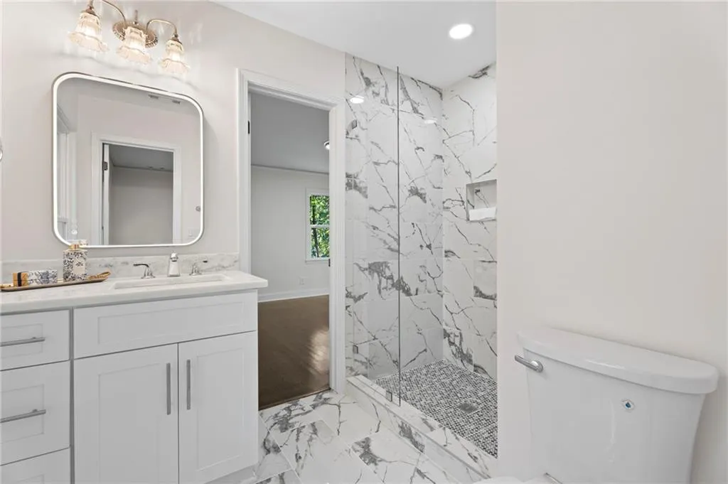 White shaker-style vanity with chrome hardware and a rectangular undermount sink