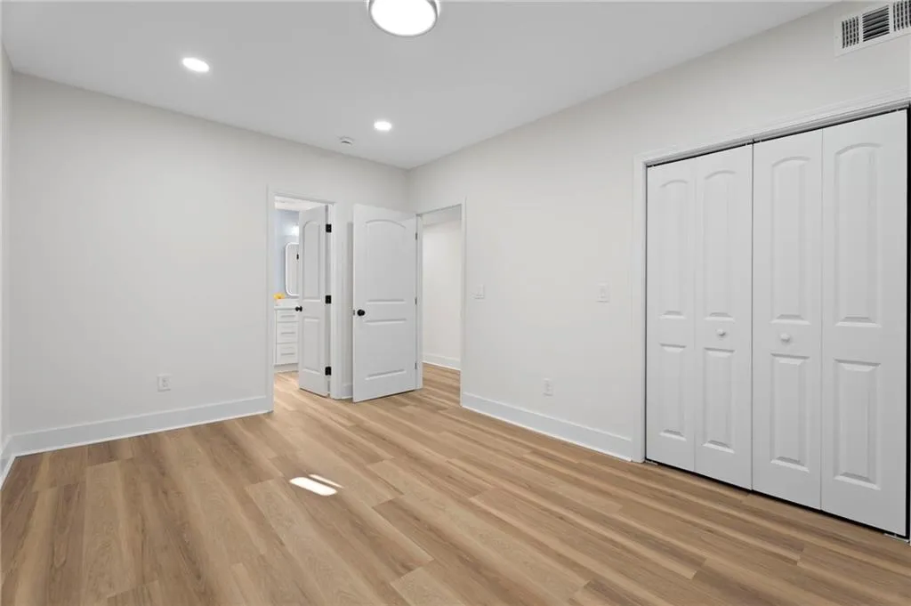 Wood-finish flooring, recessed lighting, and a white bi-fold closet