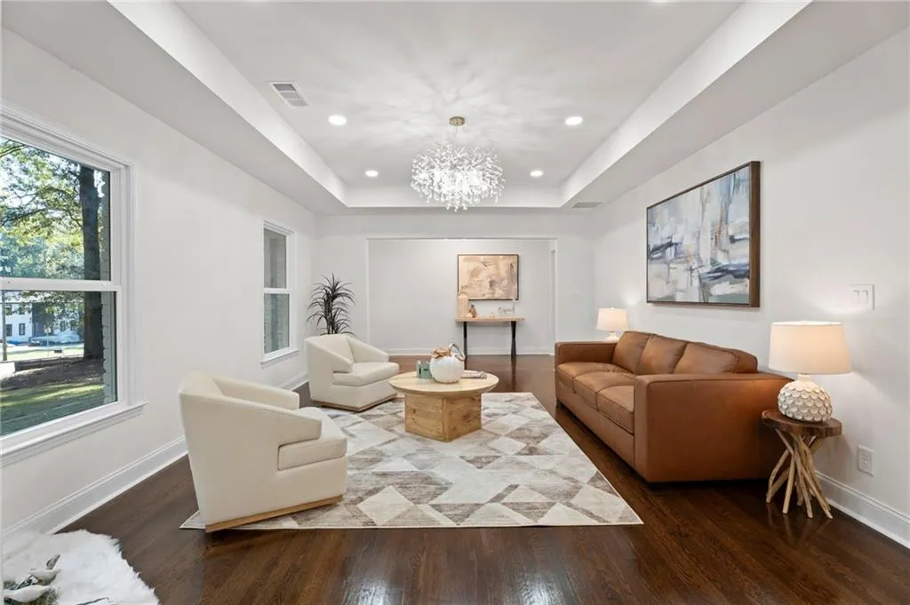 Tray ceiling with recessed lighting and a decorative chandelier