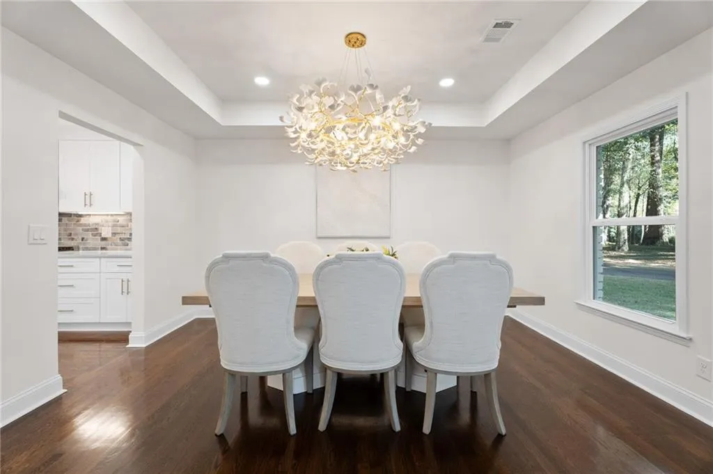 Tray ceiling with recessed lighting and a central decorative chandelier
