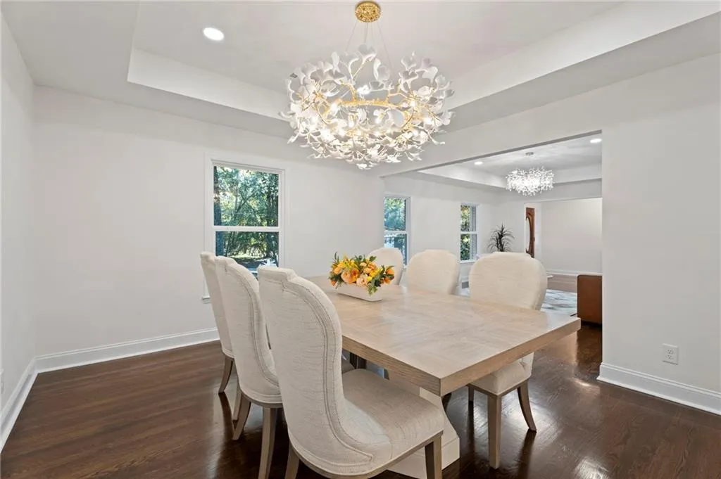 Dark wood-finish flooring, recessed lighting, and a tray ceiling
