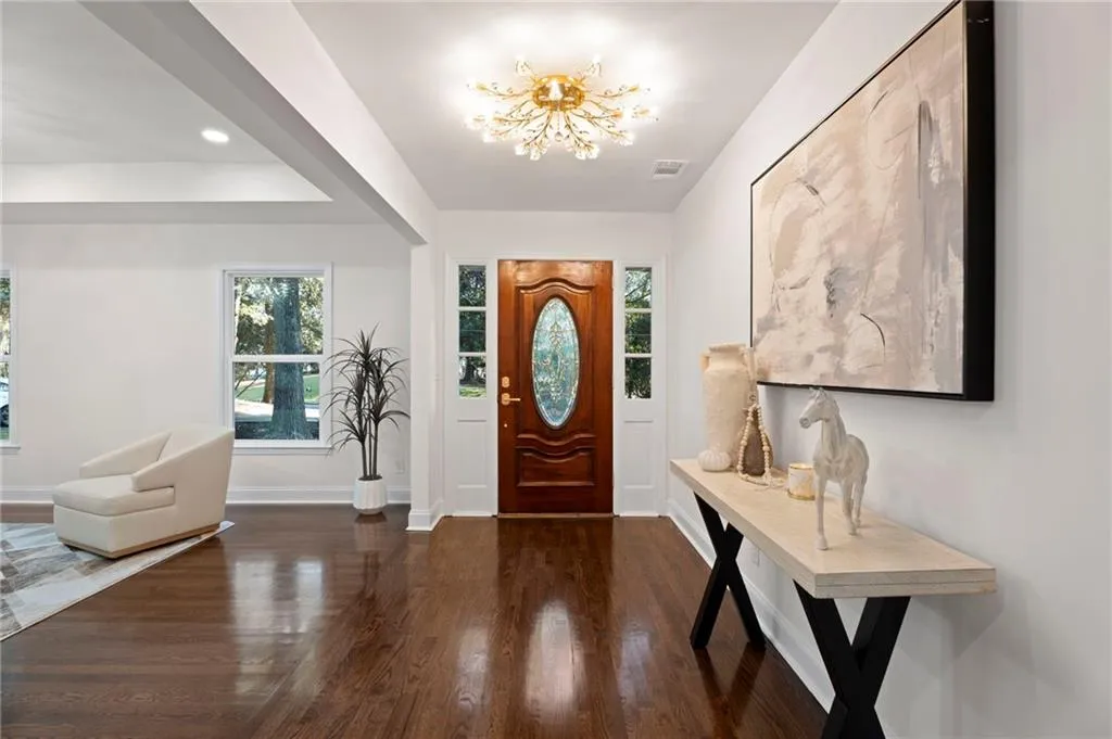 Wood-finish flooring throughout, bright recessed lighting, and a decorative ceiling fixture
