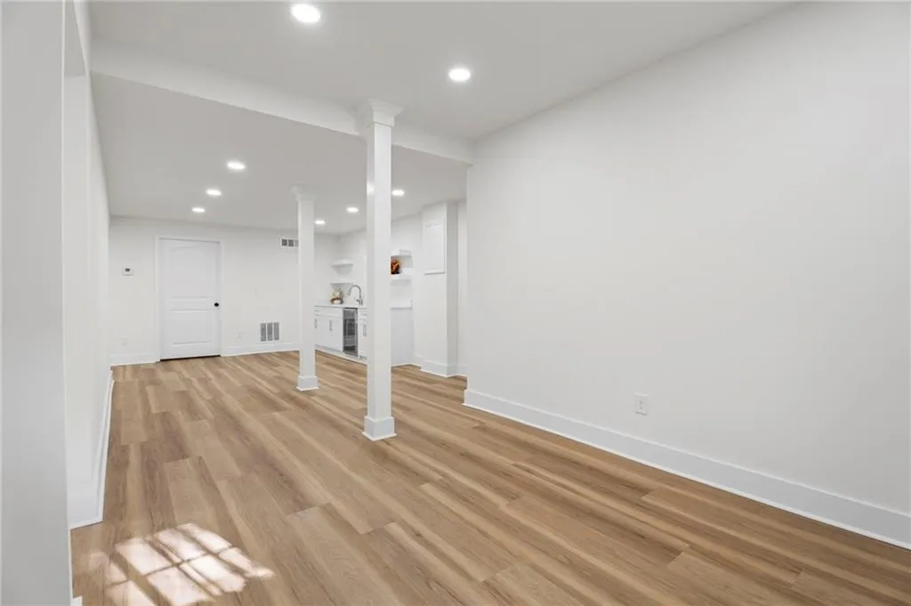 Recessed lighting illuminates wood-finish flooring