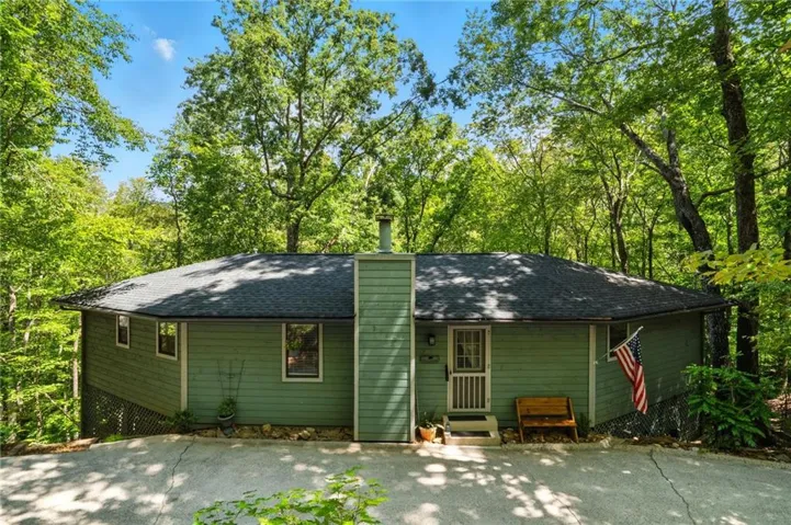 Rear view of property featuring entry steps and roof with shingles