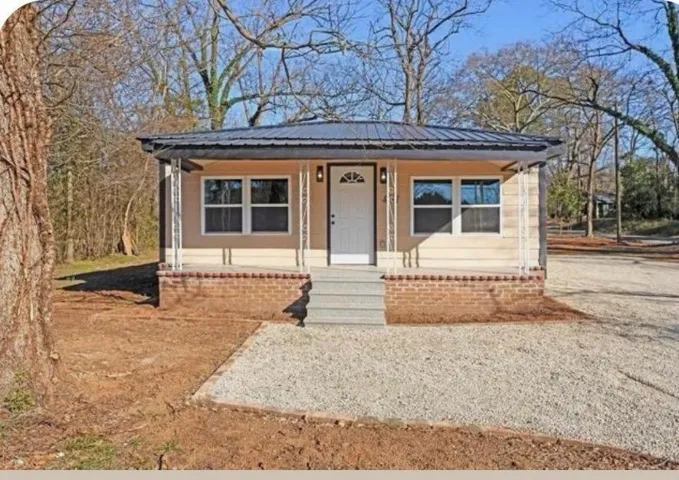 Light-colored siding exterior with a dark metal roof