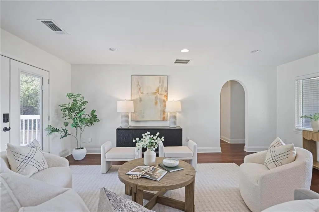 Living area featuring healthy amount of natural light, arched walkways, wood finished floors, recessed lighting, and french doors Living area featuring healthy amount of natural light, arched walkways, wood finished floors, recessed lighting, and french doors