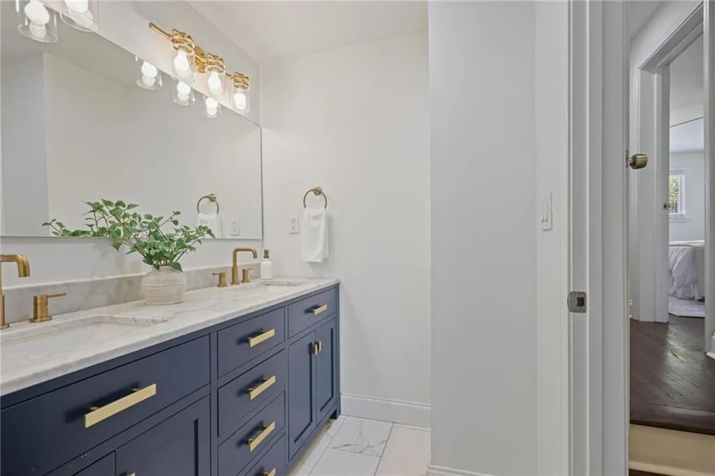 Ensuite bathroom with double vanity and light marble finish floors Ensuite bathroom with double vanity and light marble finish floors