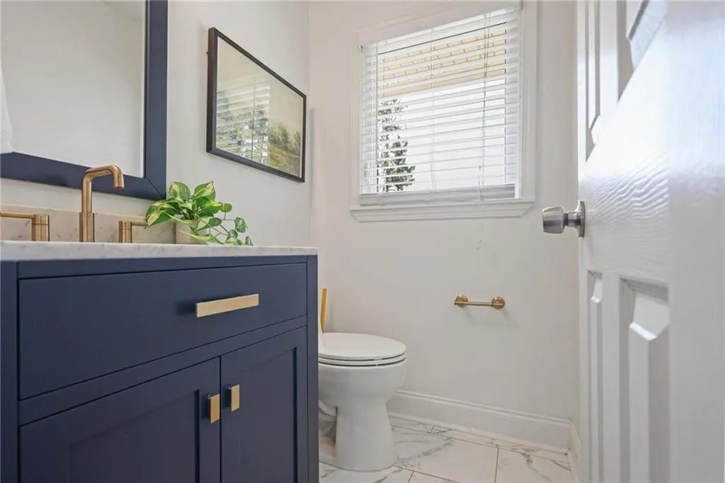 Half bath featuring vanity and light marble finish floors Half bath featuring vanity and light marble finish floors