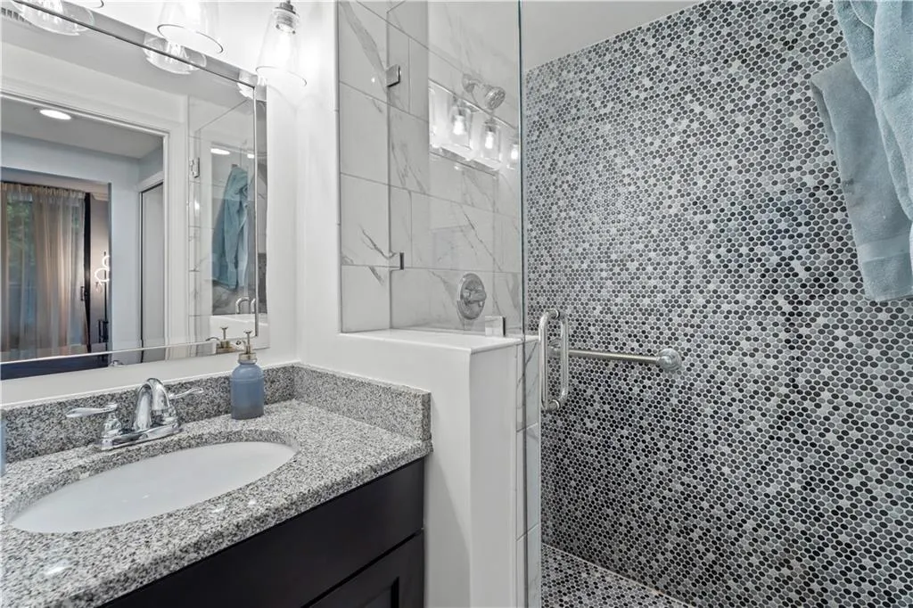 Bathroom featuring vanity and tiled shower