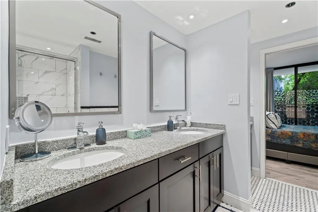 Bathroom featuring ensuite bathroom, double vanity, recessed lighting, and a shower with door