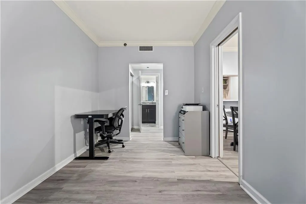 Office area featuring light wood finished floors and crown molding