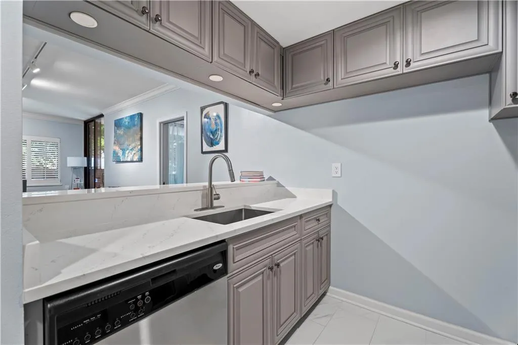 Kitchen featuring dishwasher, gray cabinets, ornamental molding, light stone countertops, and track lighting