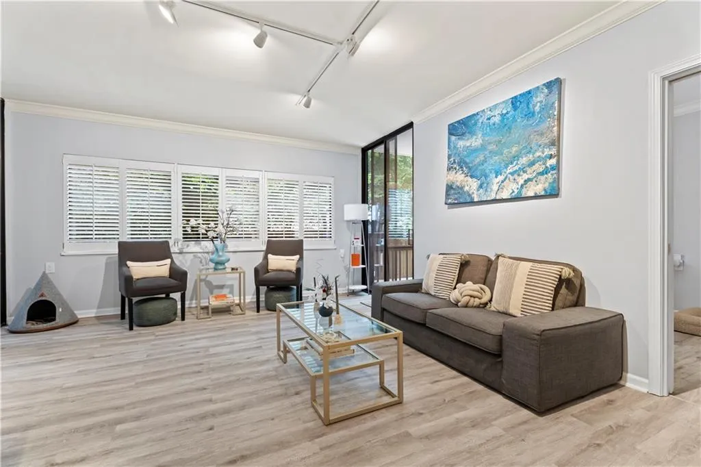 Living area featuring rail lighting, crown molding, and wood finished floors