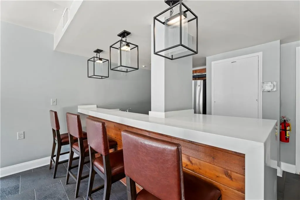 Indoor bar with baseboards and freestanding refrigerator