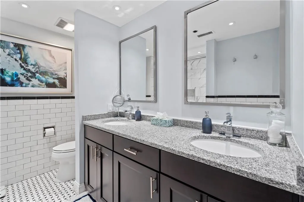 Full bath with double vanity, tile walls, recessed lighting, and tile patterned flooring