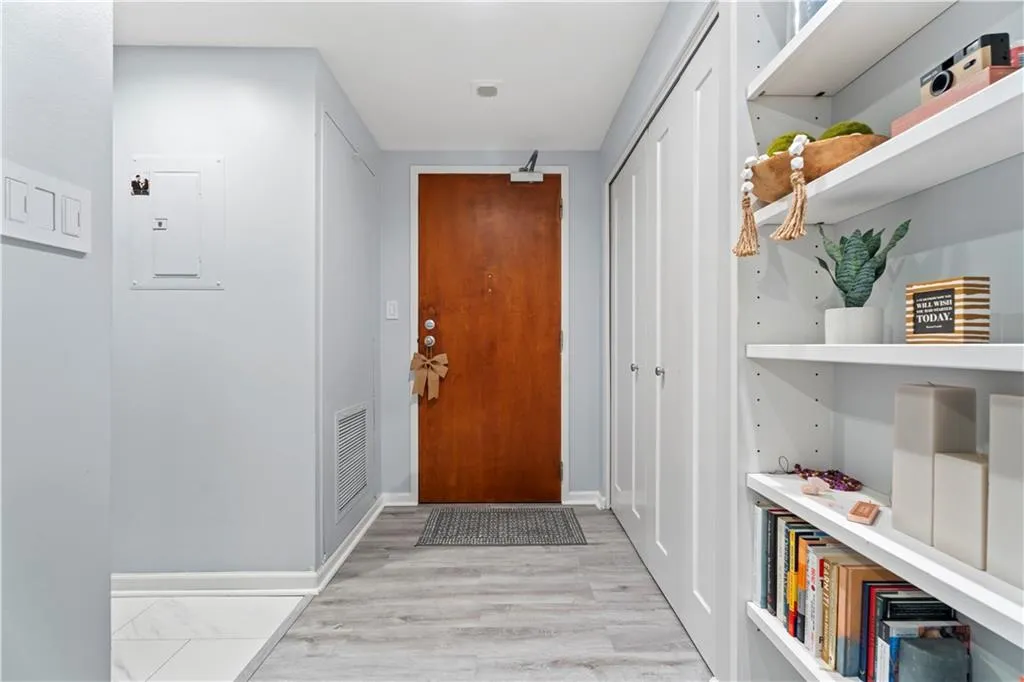 Doorway with electric panel and light wood-style floors