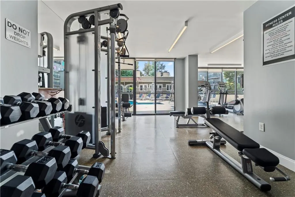 Exercise room with baseboards and a wall of windows