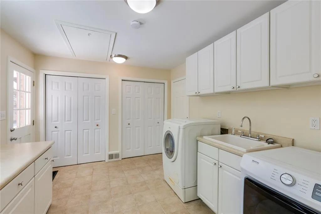 Large Laundry/Mudroom with Cabinetry, Folding Area, Sink & Dual Closets