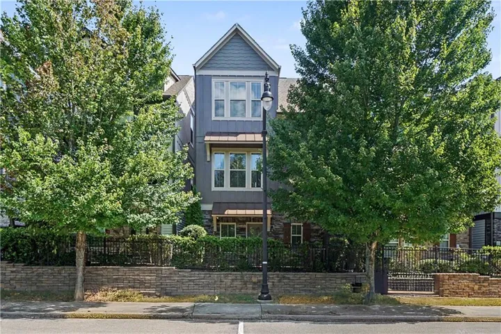 Three-story residence featuring a gabled roofline and multiple windows