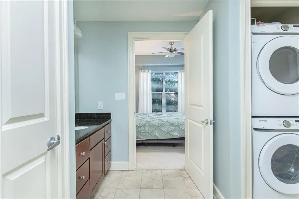 Laundry area en suite featuring newer stacked washer and dryer