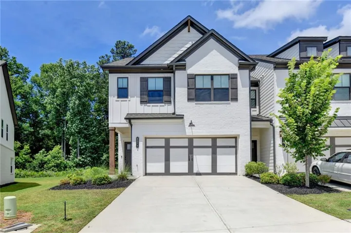 White brick exterior with dark trim accents and decorative shutters