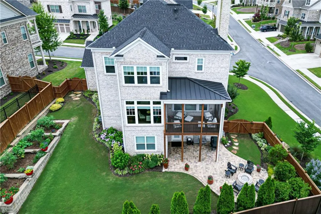 Back of property featuring a patio area, a fenced backyard, a sunroom, a chimney, and a garden