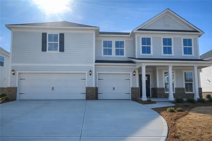 Craftsman inspired home featuring brick siding, a garage, driveway, and covered porch