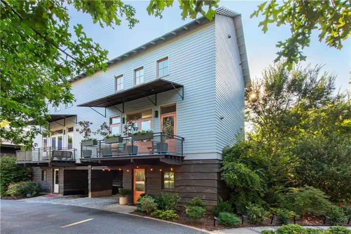 Modern siding exterior with multiple balconies, covered entryways, and integrated lighting