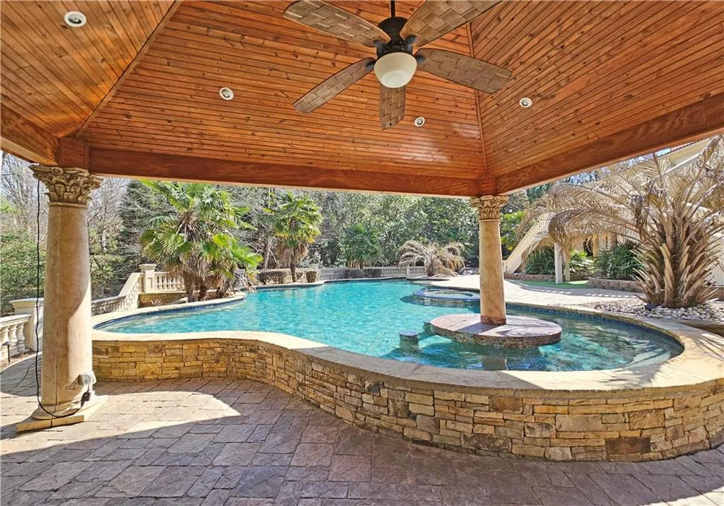 View of swimming pool with a jacuzzi, a gazebo, a patio area, and pool water feature