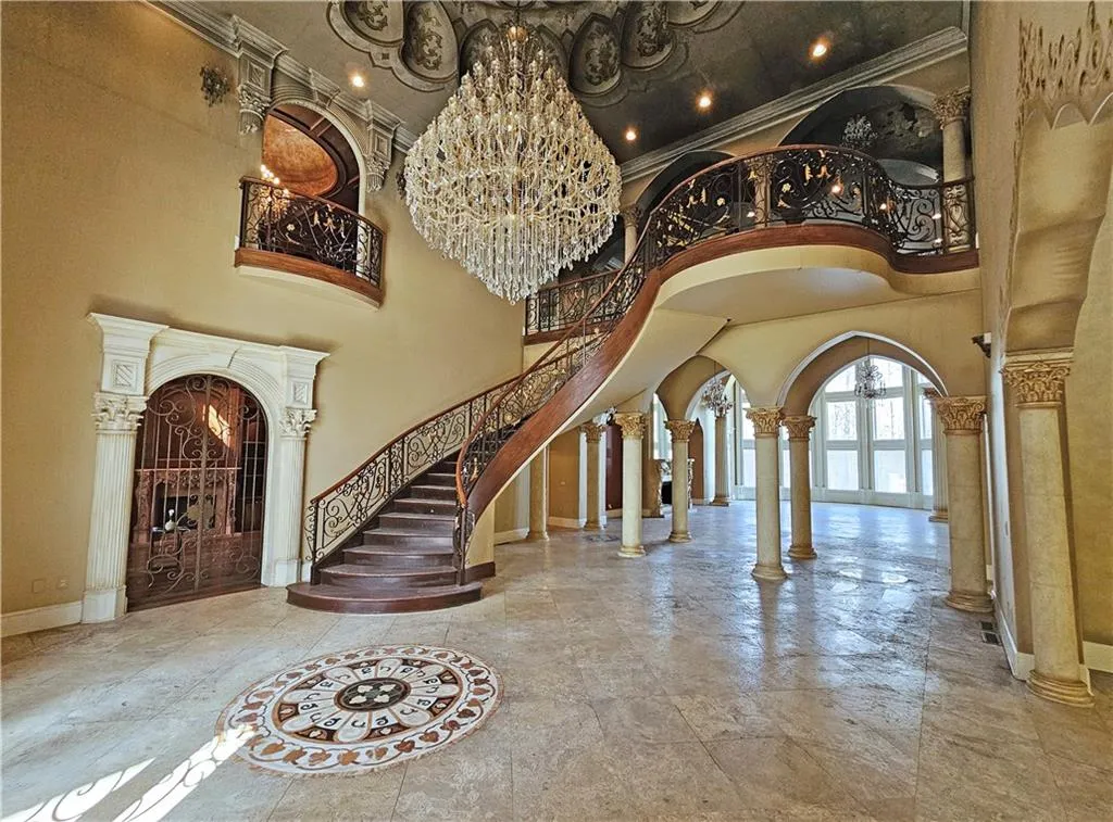 Entryway featuring a high ceiling, a chandelier, and ornate columns