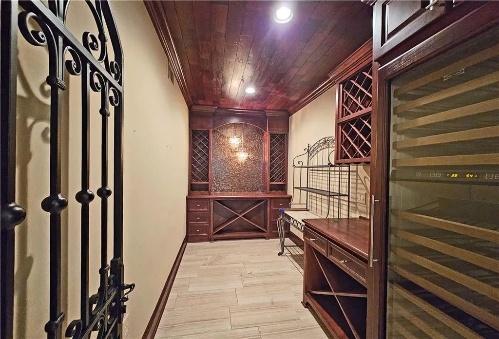Wine cellar featuring ornamental molding and wood ceiling