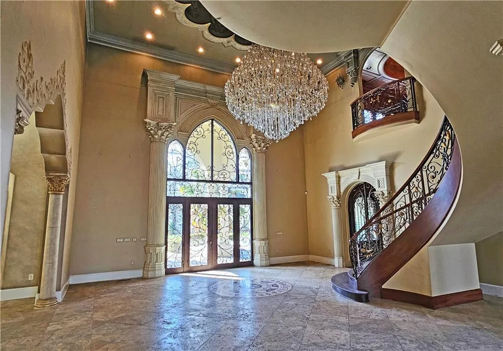 Foyer entrance with french doors, tile flooring, a notable chandelier, and a high ceiling