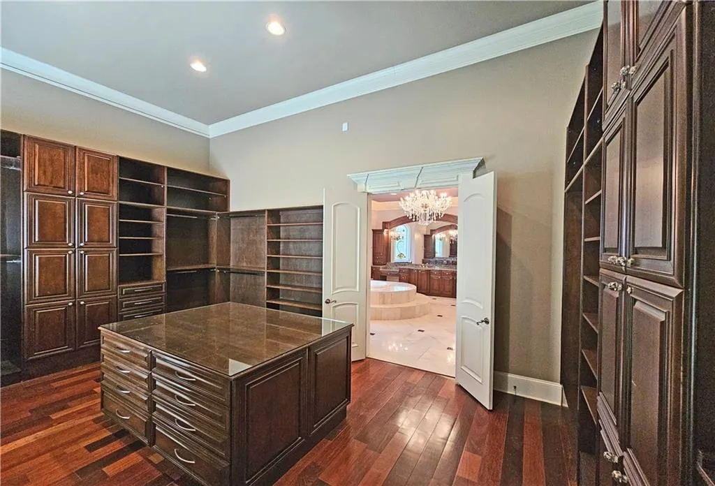 Office space with an inviting chandelier, ornamental molding, and dark wood-type flooring