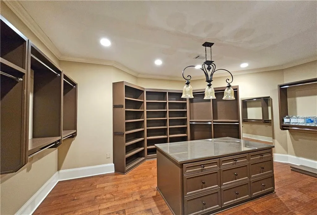 Spacious closet featuring a chandelier and hardwood / wood-style floors