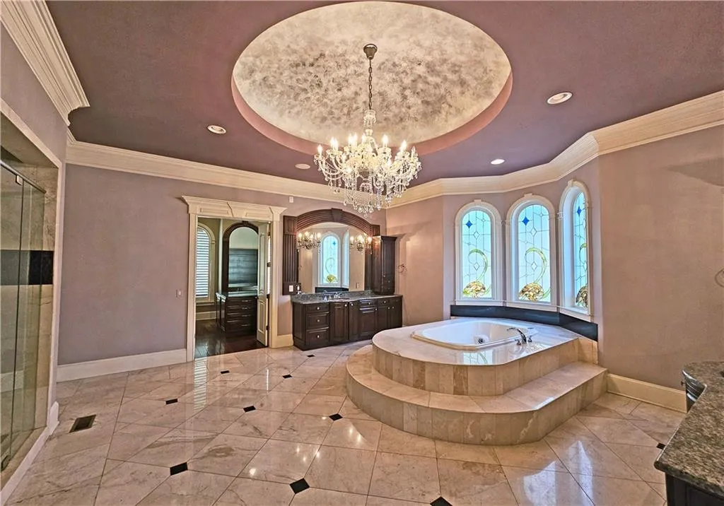 Bathroom featuring a tray ceiling, vanity, tile floors, and a chandelier