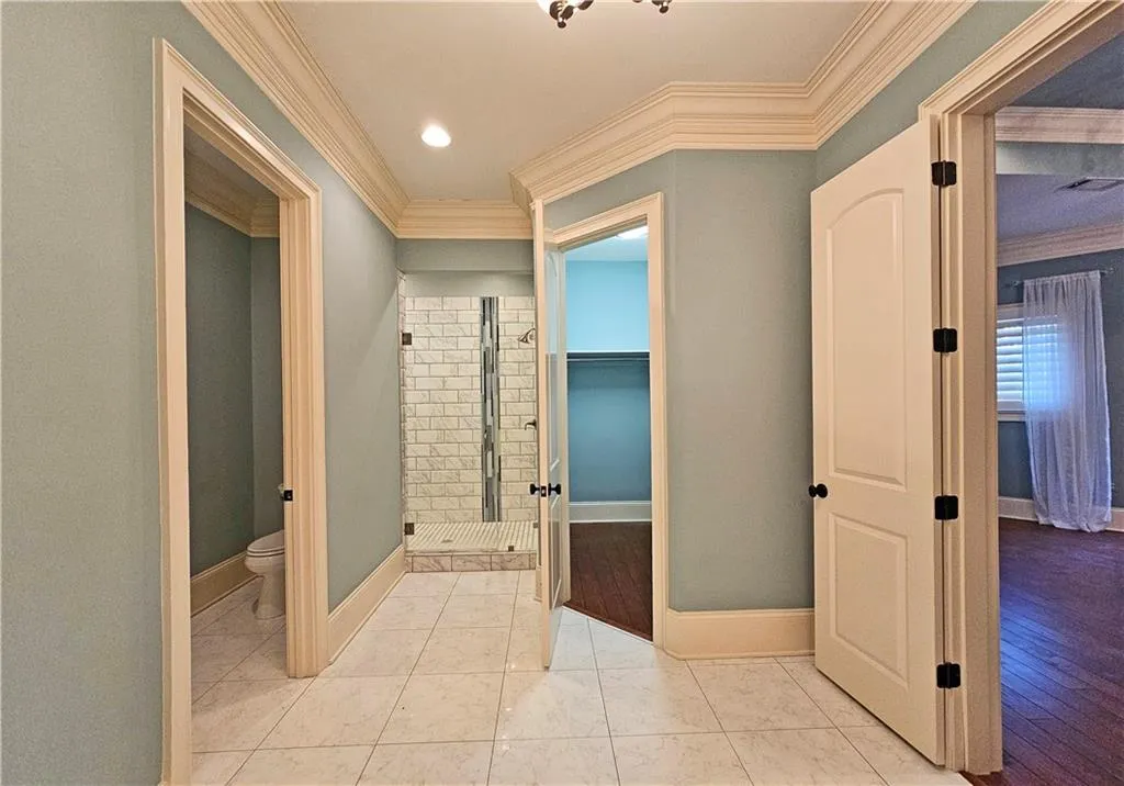 Hallway featuring light tile flooring and ornamental molding