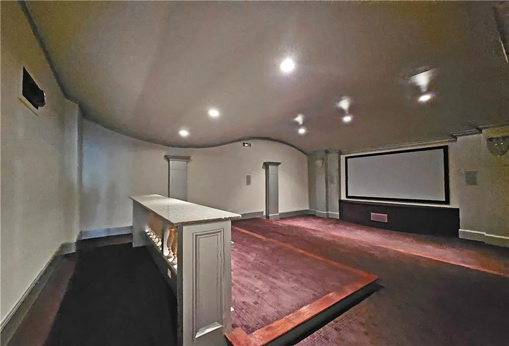 Home theater featuring dark carpet and decorative columns
