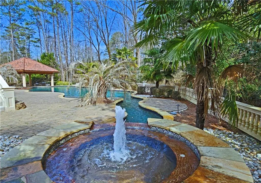View of swimming pool with a gazebo and pool water feature
