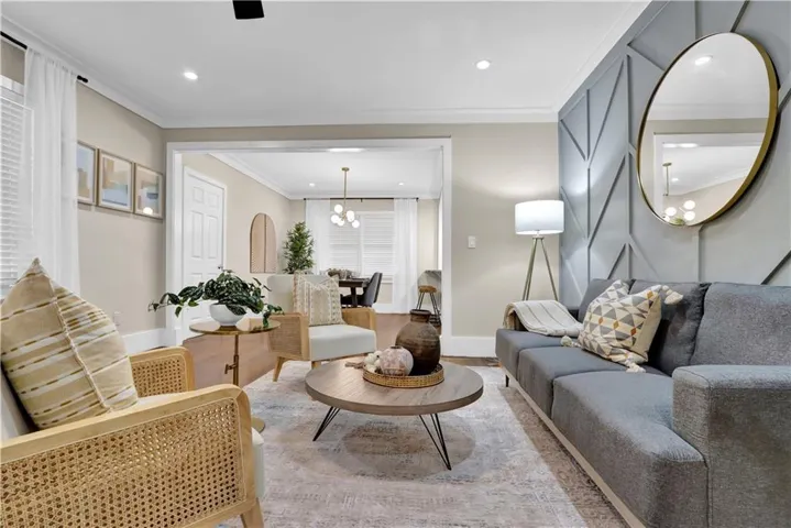 Recessed lighting, crown molding, and a decorative accent wall with geometric paneling