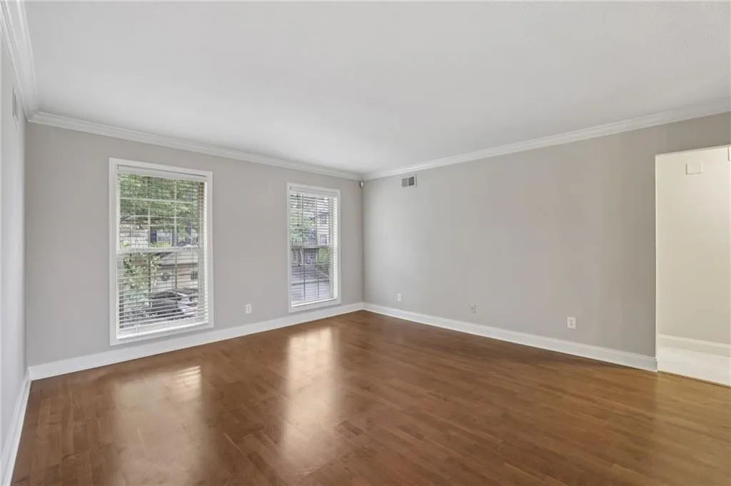 Spare room with ornamental molding and dark wood finished floors