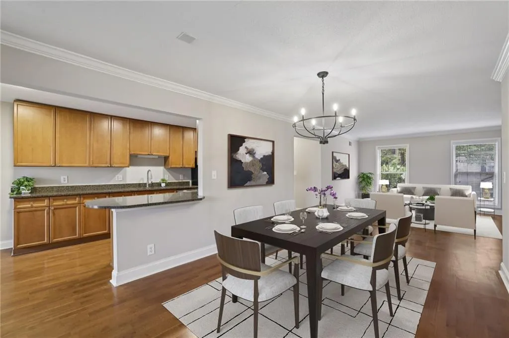 Digitally staged. Dining space with dark wood-type flooring, crown molding, and a chandelier