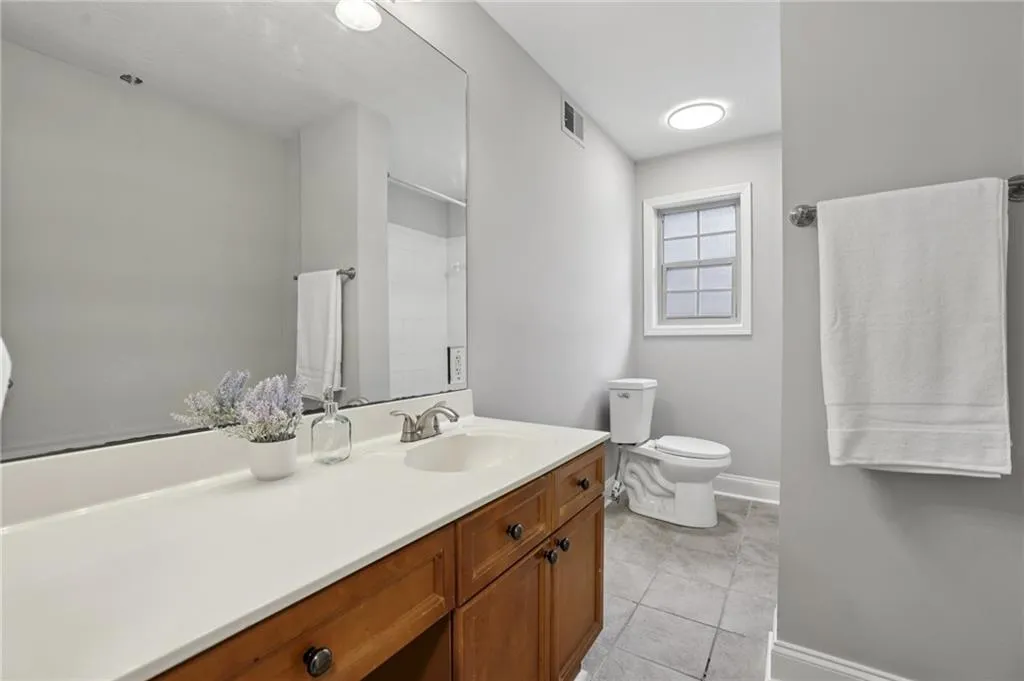 Full bathroom featuring vanity, tile patterned floors, and a shower with shower curtain