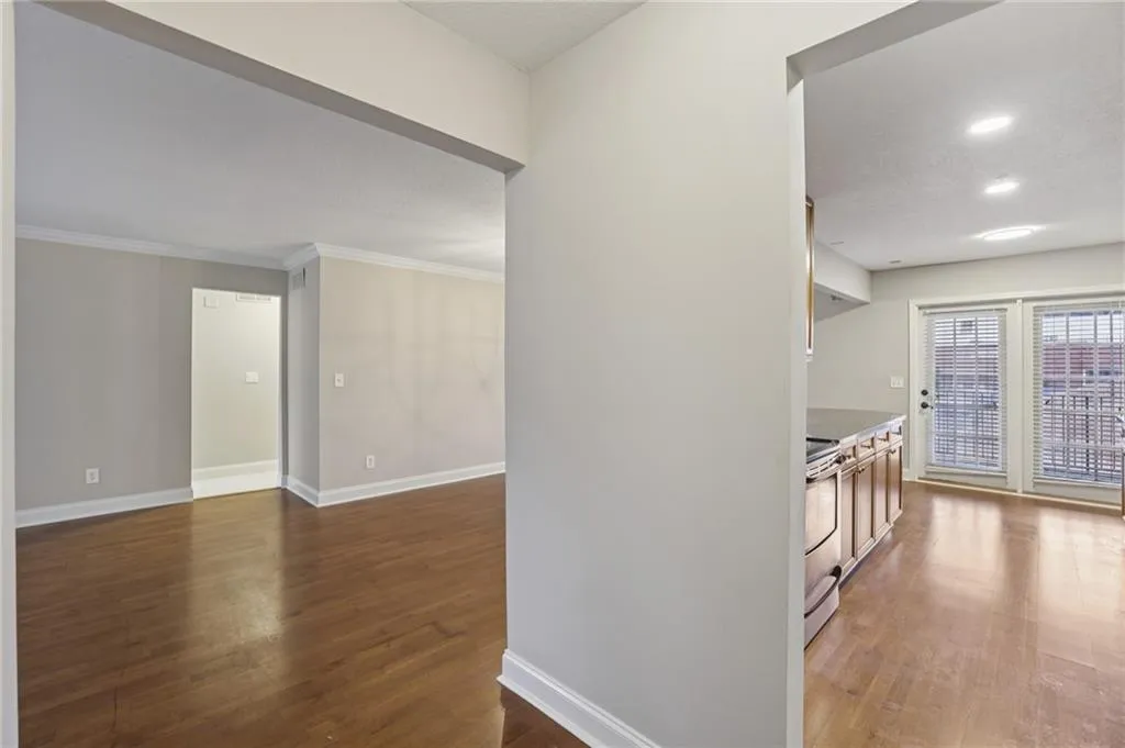 Corridor featuring dark wood-type flooring, and crown molding