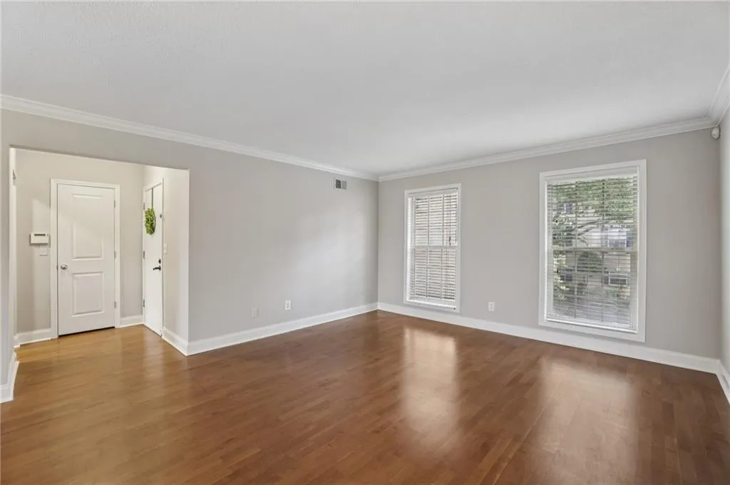 Unfurnished room featuring crown molding and dark wood-type flooring