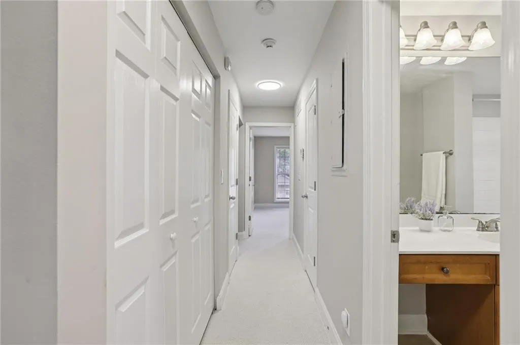 Hall featuring light carpet and baseboards