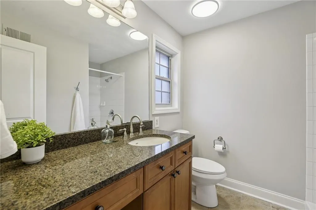 Full bathroom with a shower, vanity, and tile patterned flooring