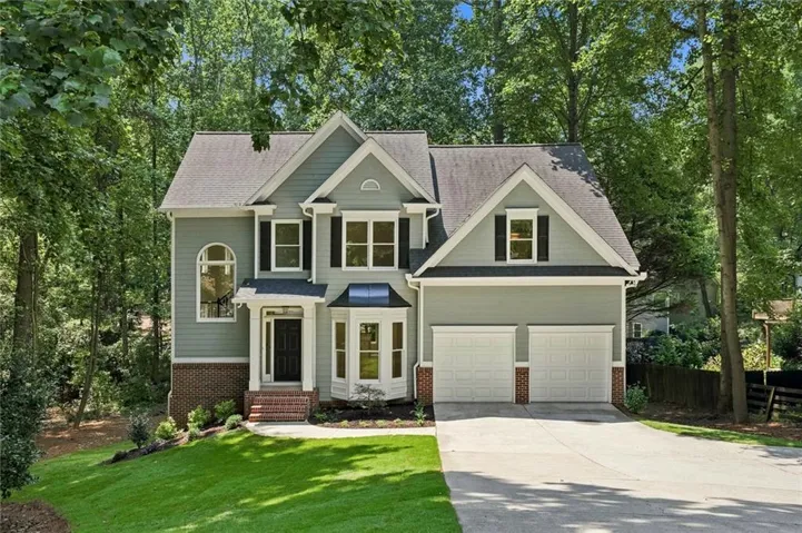 Gabled roof line home featuring a two-car garage, frame and brick exterior.