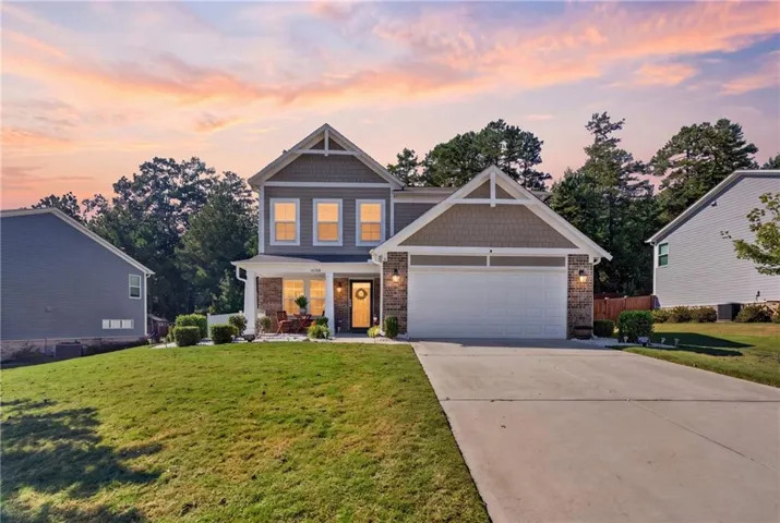 Two-story residence featuring a brick and siding exterior, an attached two-car garage, and a concrete driveway