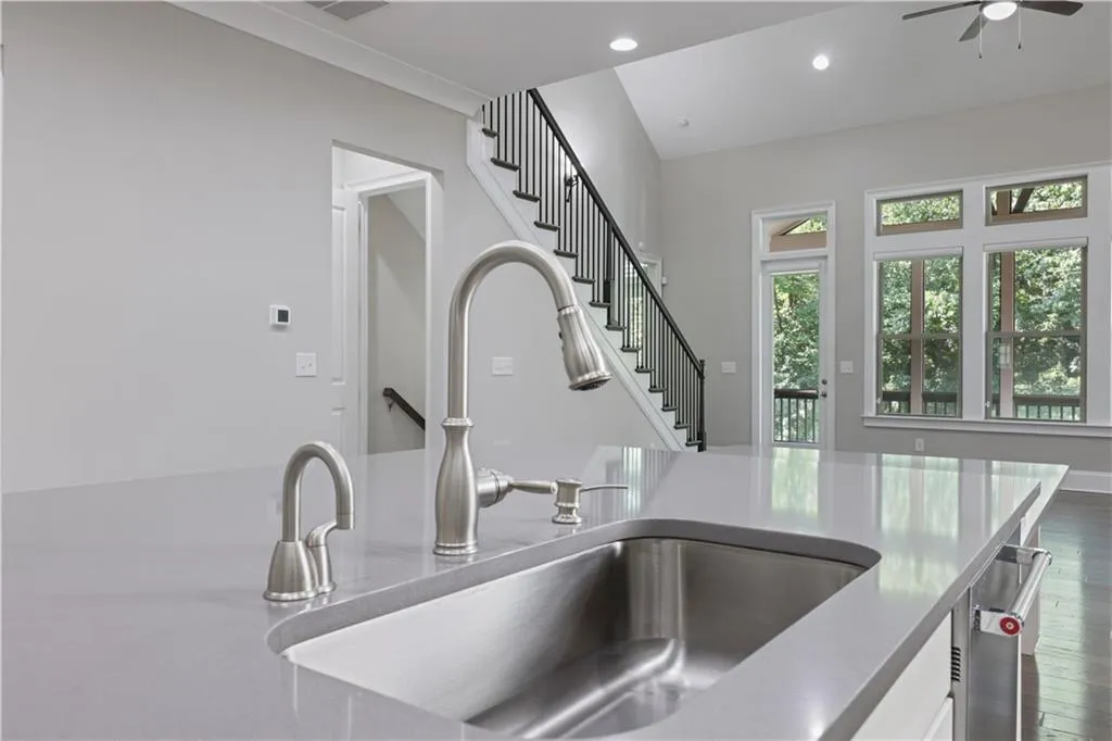 Kitchen featuring dark wood-type flooring, ceiling fan, and sink